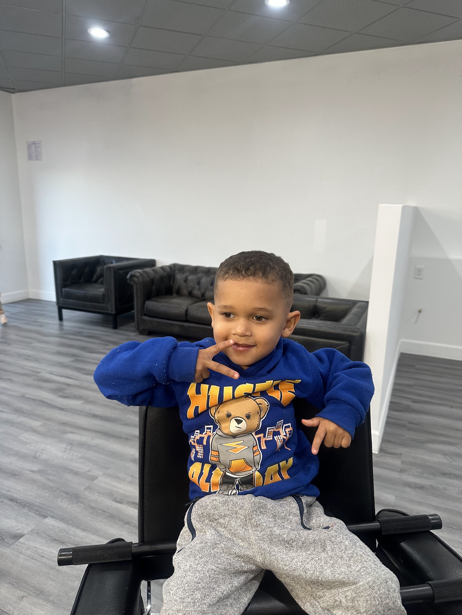 Young boy with a fresh haircut posing in a barber chair